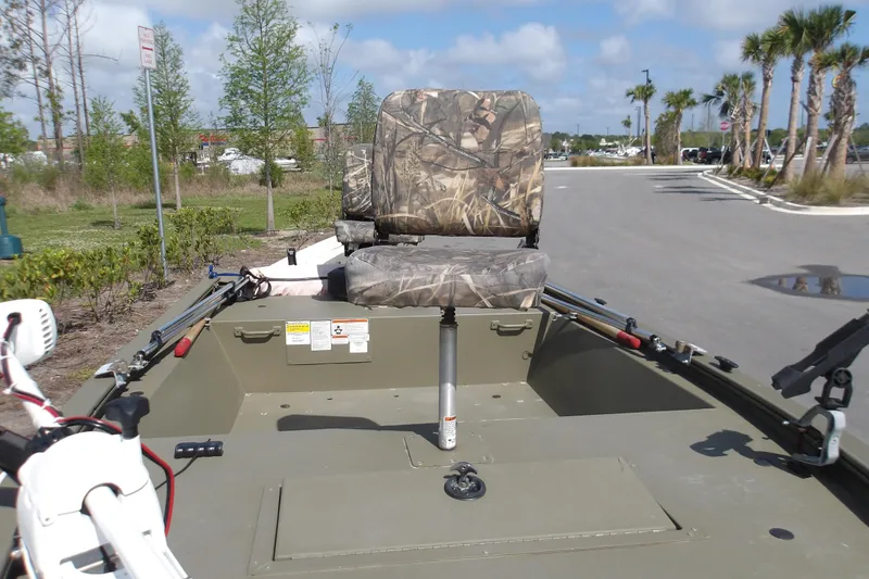 Slide: The Image of 2019 Tracker Grizzly 1448 Jon boat with camo seats in a parking lot. - 7