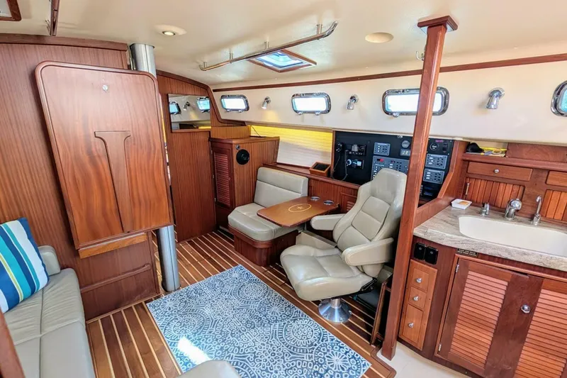 Slide: The Image of Interior of 1999 Island Packet 349 yacht with wood finish, seating, and navigation controls. - 10