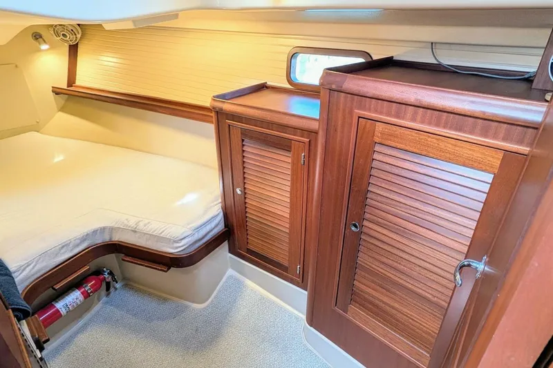 Slide: The Image of Cozy cabin interior of 1999 Island Packet 349 sailboat with wooden cabinets and bed. - 12