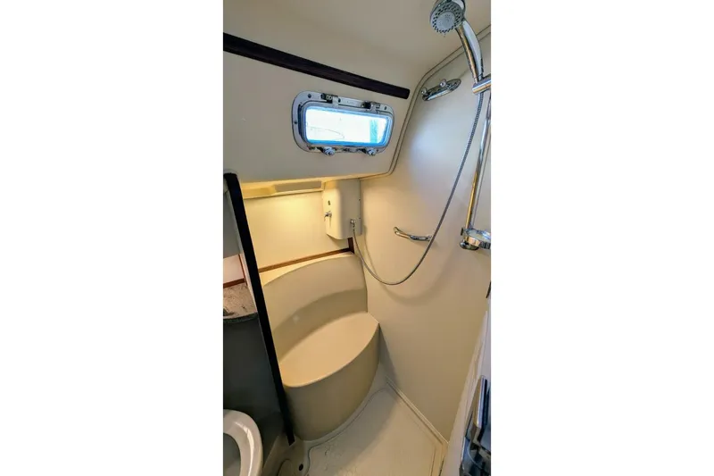 Slide: The Image of Island Packet 349 (1999) yacht bathroom with shower, porthole, and compact design. - 14