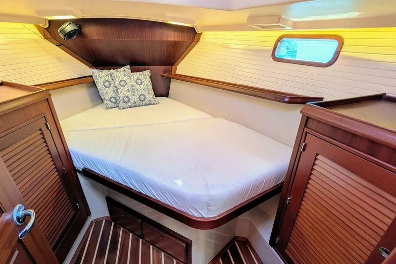 Slide: The Image of Cozy cabin interior of 1999 Island Packet 349 sailboat with wooden accents and bedding. - 16