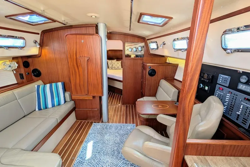 Slide: The Image of Interior of 1999 Island Packet 349 sailboat with wood paneling and cozy seating area. - 8