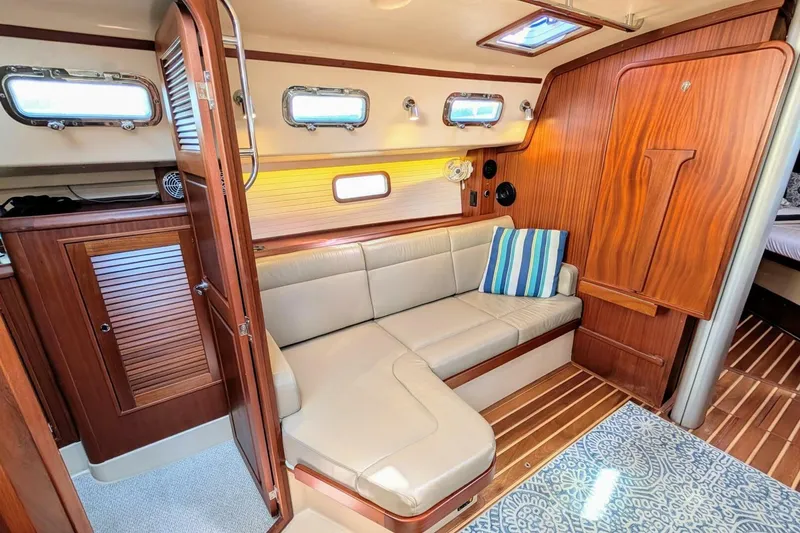 Slide: The Image of Interior of 1999 Island Packet 349 yacht with cozy seating and wooden accents. - 9
