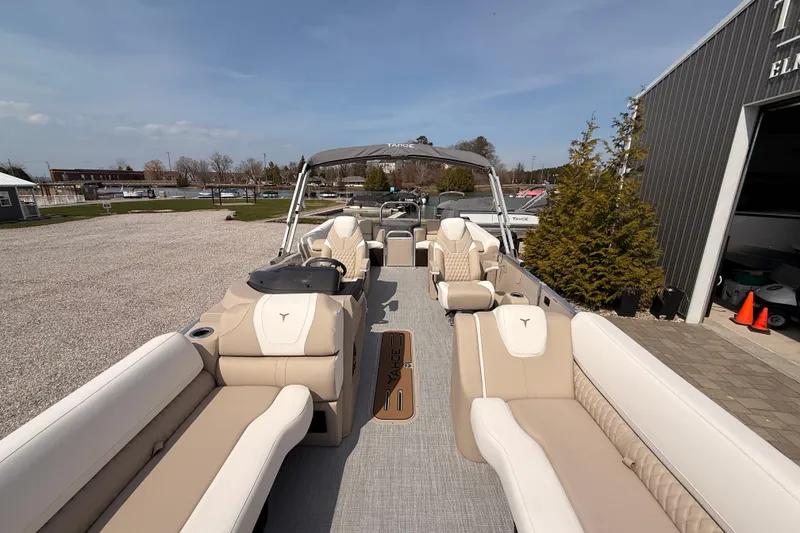 Slide: The Image of 2026 Tahoe Pontoon Cascade Quad Lounger, 25-foot luxury boat with beige seating, docked outdoors. - 12