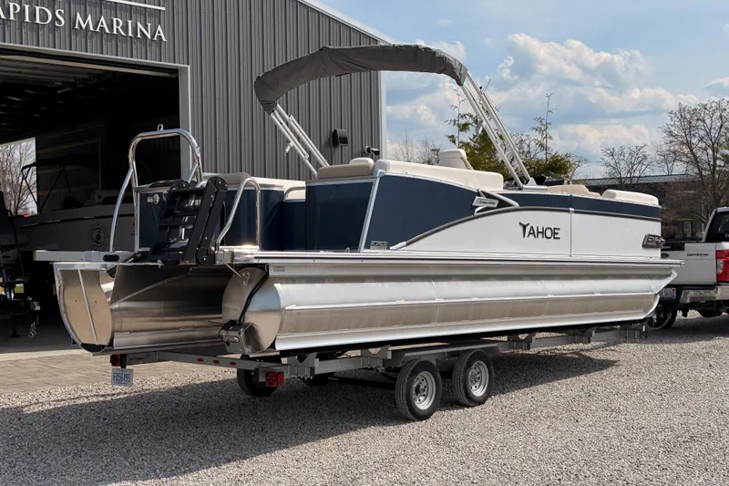 Slide: The Image of 2026 Tahoe Pontoon Cascade Quad Lounger 25' at marina, on trailer, under blue sky. - 5