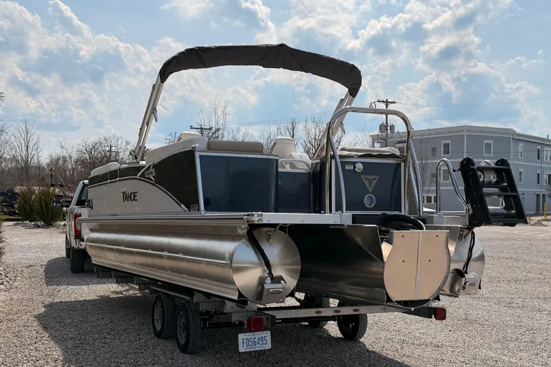 Slide: The Image of 2026 Tahoe Pontoon Cascade Quad Lounger 25' on trailer, parked outdoors under cloudy sky. - 7