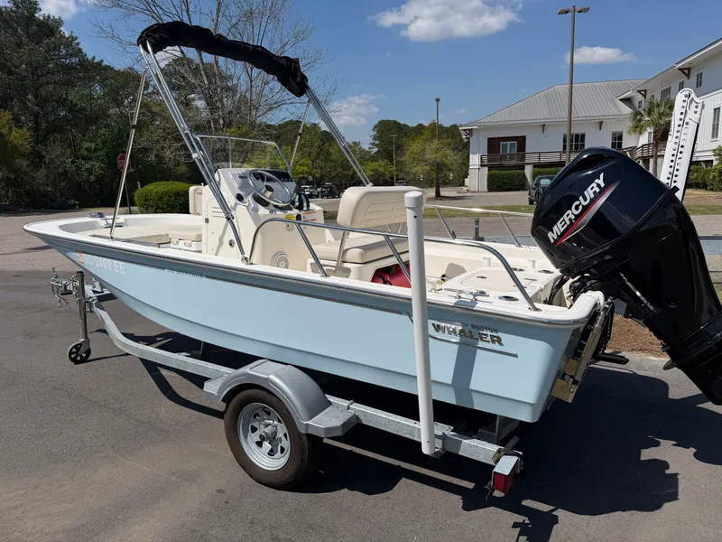 Slide: The Image of 2024 Boston Whaler 150 Montauk boat on trailer, featuring Mercury outboard motor. - 0