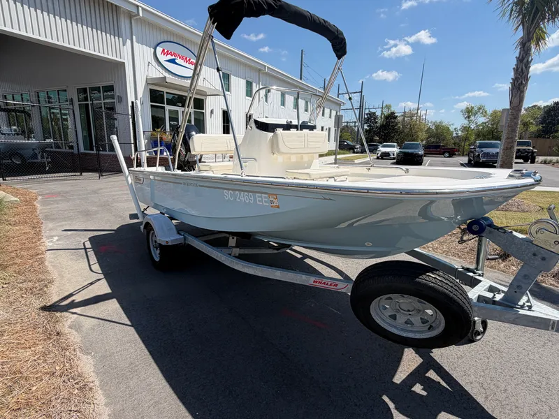 Slide: The Image of 2024 Boston Whaler 150 Montauk on trailer outside marine store. - 2