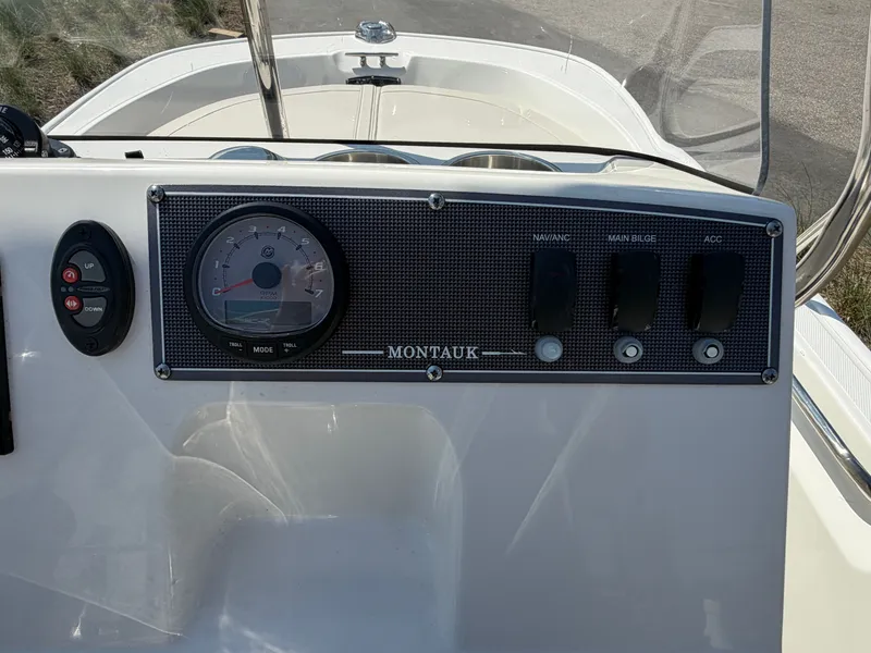 Slide: The Image of Dashboard of 2024 Boston Whaler 150 Montauk with switches and tachometer. - 8