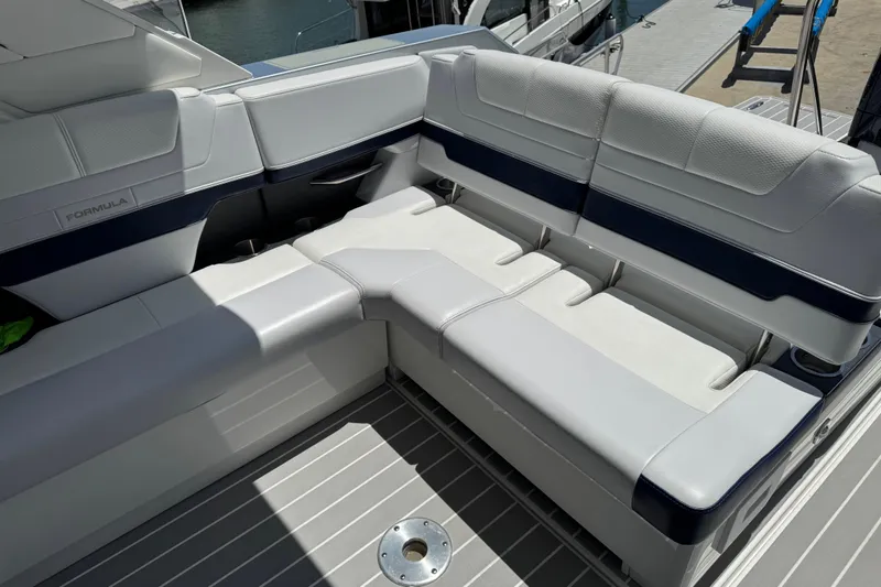Slide: The Image of 2024 Formula 380 Super Sport Crossover OB boat seating area, featuring sleek white and navy upholstery. - 16