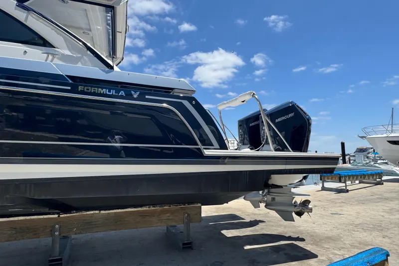 Slide: The Image of 2024 Formula 380 Super Sport Crossover OB boat with Mercury engines at a marina. - 2
