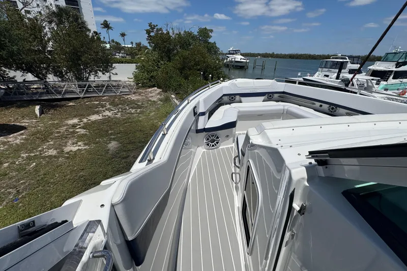 Slide: The Image of 2024 Formula 380 Super Sport Crossover OB boat deck with seating, docked near water. - 23