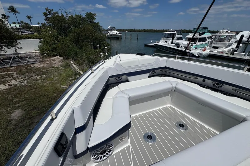Slide: The Image of 2024 Formula 380 Super Sport Crossover OB boat with spacious seating at a marina. - 26