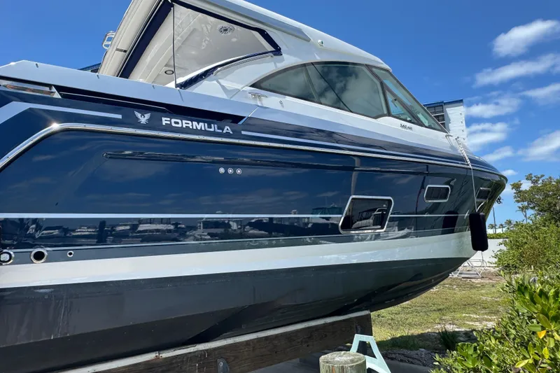 Slide: The Image of 2024 Formula 380 Super Sport Crossover OB boat docked under clear blue sky. - 8