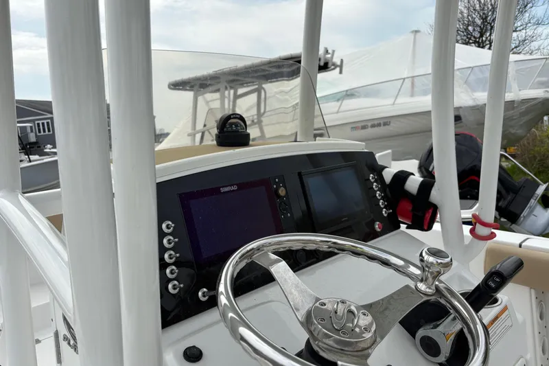 Slide: The Image of 2018 Sportsman Heritage 231 Center Console boat dashboard with steering wheel and navigation equipment. - 7
