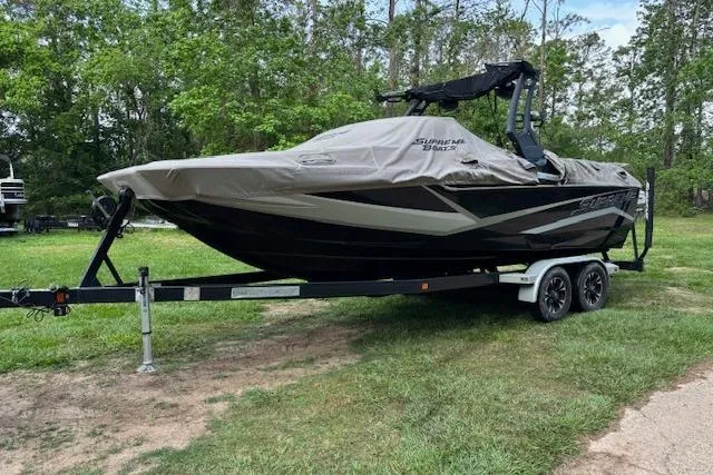 Slide: The Image of 2019 Supreme ZS232 boat on trailer, covered, parked on grass. - 6