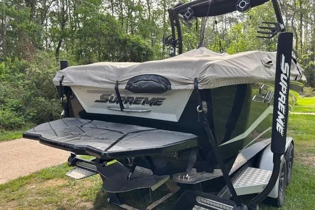 Slide: The Image of 2019 Supreme ZS232 boat with cover, parked on grass near trees. - 8