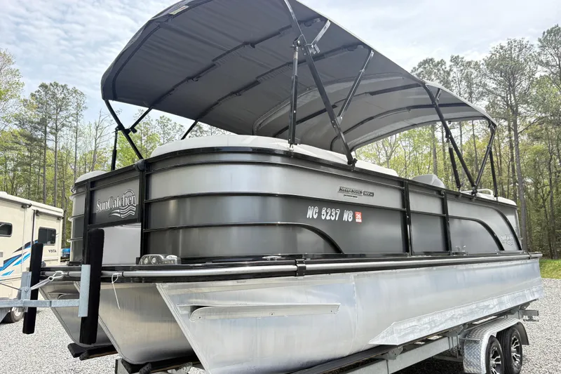 Slide: The Image of 2023 SunCatcher X322 RC pontoon boat on trailer, featuring sleek design and canopy. - 4