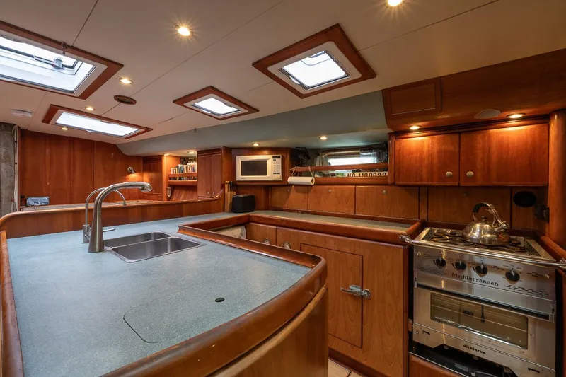 Slide: The Image of Luxurious 2001 Kanter Bougainvillea 62 yacht kitchen with modern amenities and wooden cabinetry. - 23