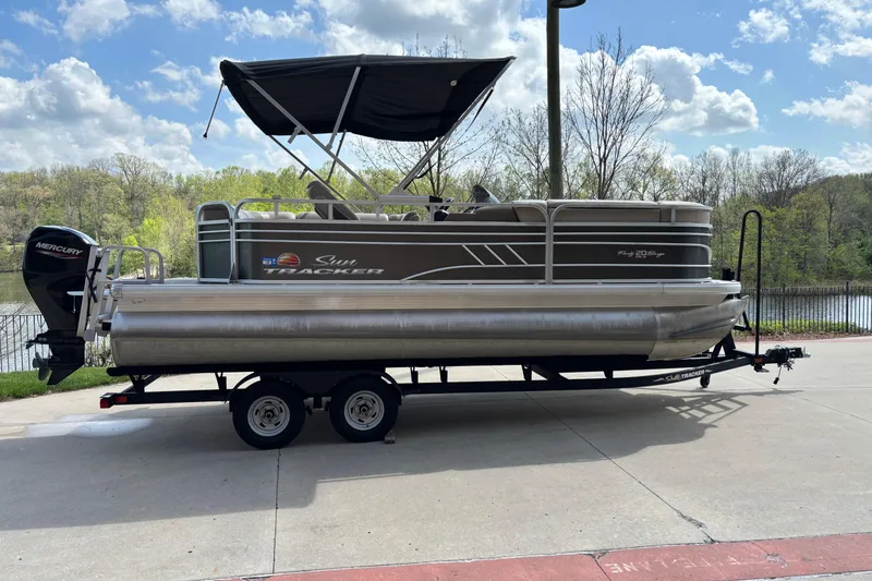 The Image of 2022 Sun Tracker Party Barge 20 DLX pontoon boat on trailer, parked outdoors. - 0