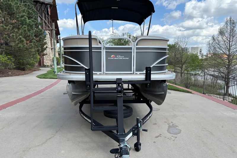 Slide: The Image of 2022 Sun Tracker Party Barge 20 DLX pontoon boat on trailer, parked outdoors. - 2