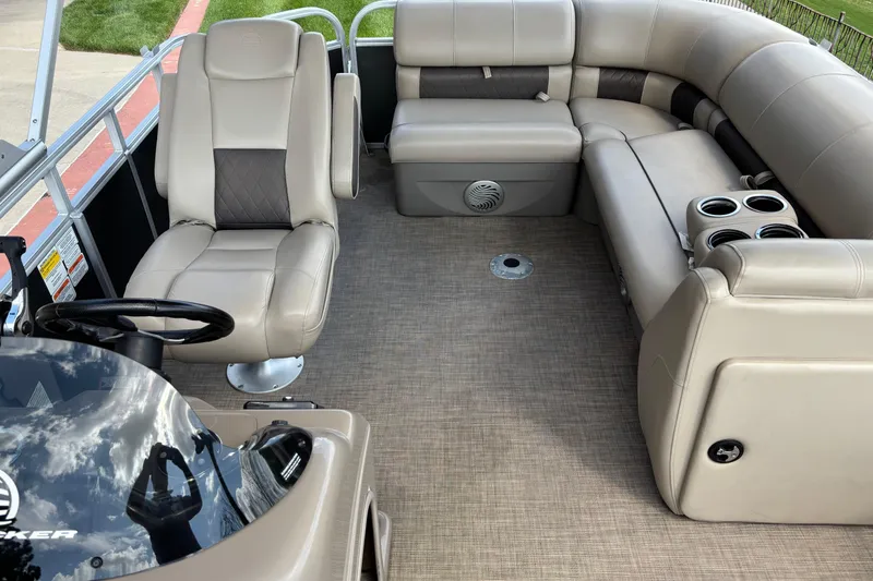 Slide: The Image of 2022 Sun Tracker Party Barge 20 DLX interior with beige seating and steering console. - 4