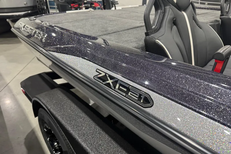 Slide: The Image of 2026 Skeeter ZXE21 boat with sleek design and glittering finish in showroom. - 2