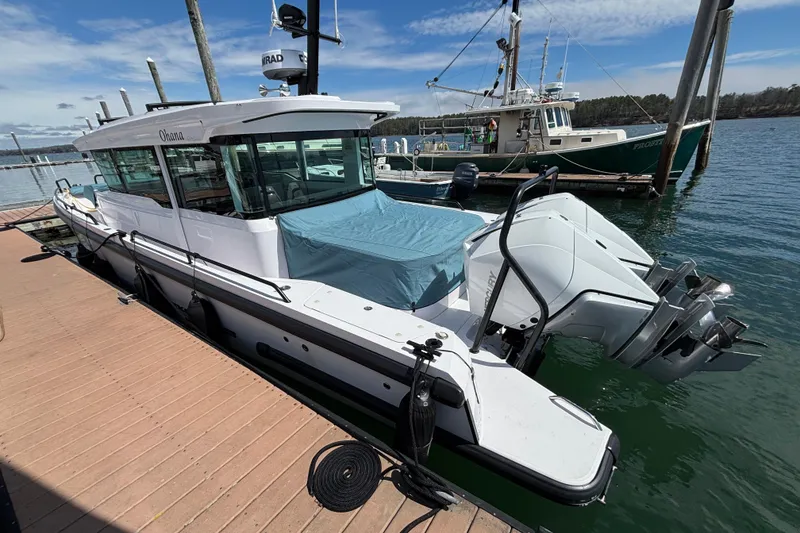 Slide: The Image of 2024 Axopar 37 XC Cross Cabin docked at marina with twin engines. - 10