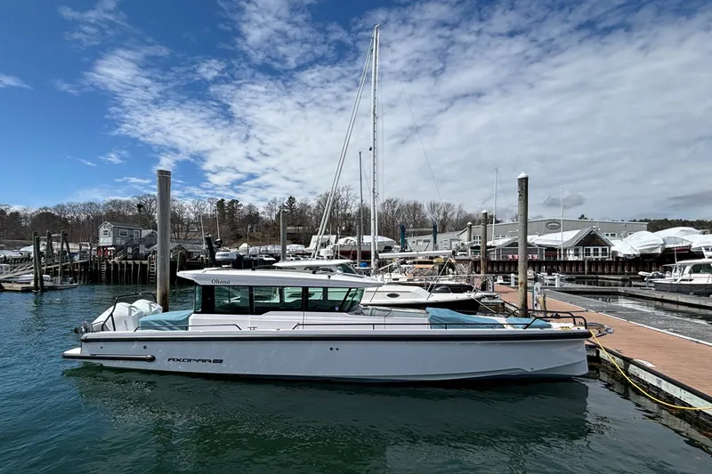 Slide: The Image of 2024 Axopar 37 XC Cross Cabin docked at a marina under a partly cloudy sky. - 11
