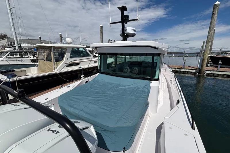 Slide: The Image of 2024 Axopar 37 XC Cross Cabin docked at marina under cloudy sky. - 12