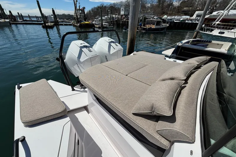 Slide: The Image of 2024 Axopar 37 XC Cross Cabin with cushioned seating, docked at a marina. - 13