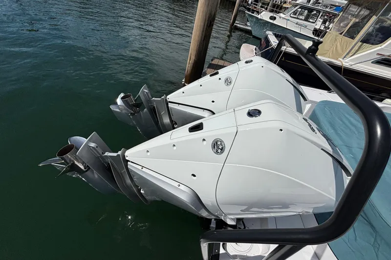 Slide: The Image of Twin outboard engines on a 2024 Axopar 37 XC Cross Cabin boat docked in water. - 14