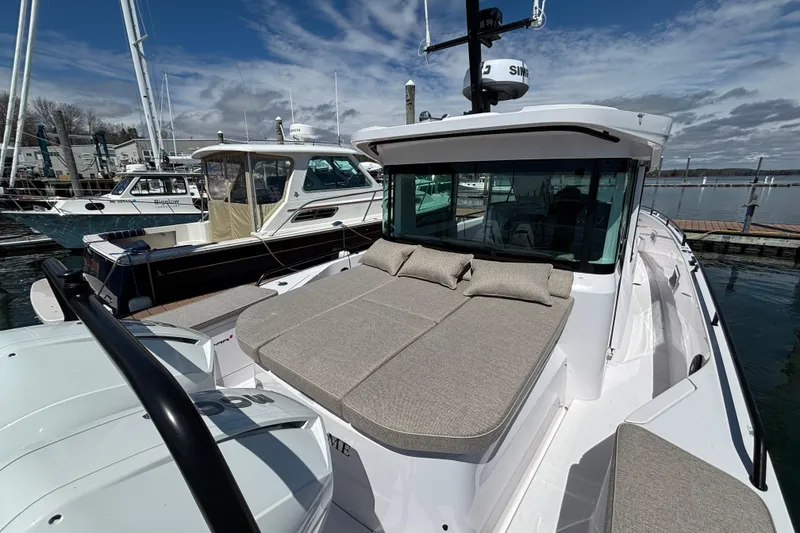 Slide: The Image of 2024 Axopar 37 XC Cross Cabin boat with cushioned deck, docked at marina. - 15