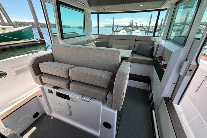 Slide: The Image of 2024 Axopar 37 XC Cross Cabin interior with gray seating and panoramic windows. - 19