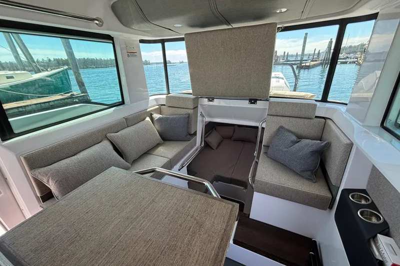 Slide: The Image of Interior of 2024 Axopar 37 XC Cross Cabin with comfortable seating and scenic marina view. - 21