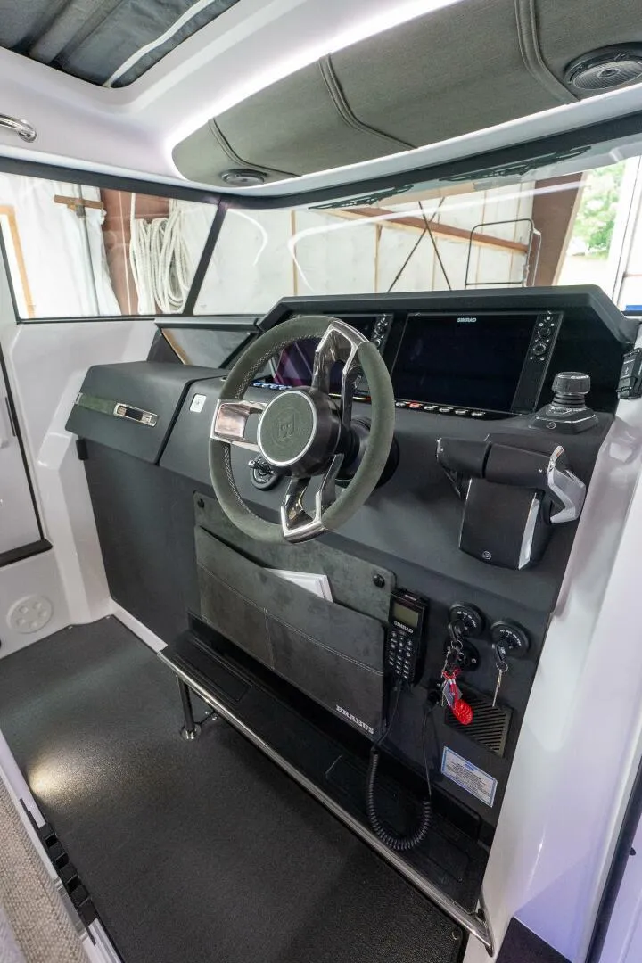Slide: The Image of 2024 Axopar 37 Cross Cabin XC helm station with modern controls and steering wheel. - 22