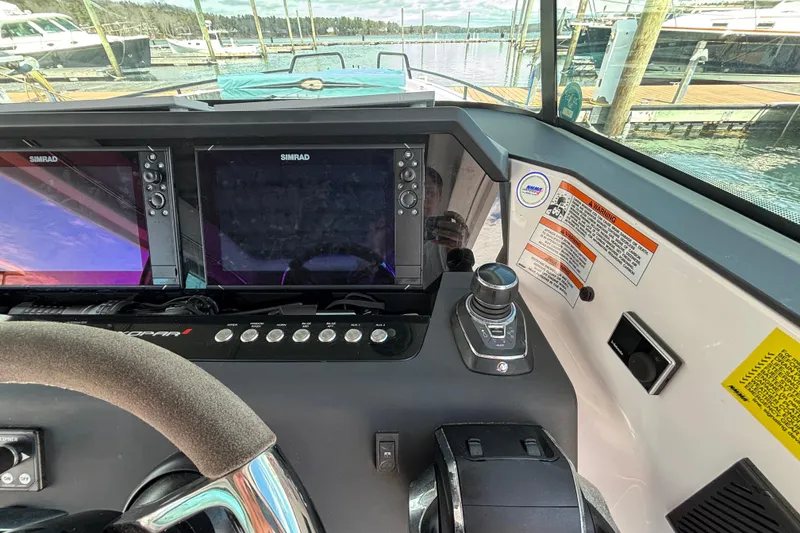 Slide: The Image of 2024 Axopar 37 XC Cross Cabin helm with Simrad displays and control panel. - 23