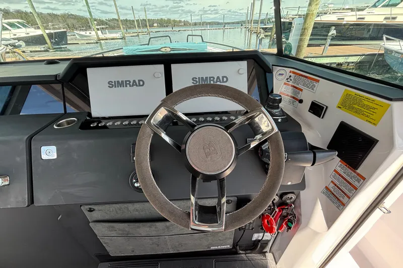 Slide: The Image of 2024 Axopar 37 XC Cross Cabin helm with Simrad displays and steering wheel. - 24