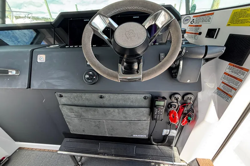 Slide: The Image of 2024 Axopar 37 XC Cross Cabin helm with steering wheel and control panel. - 25