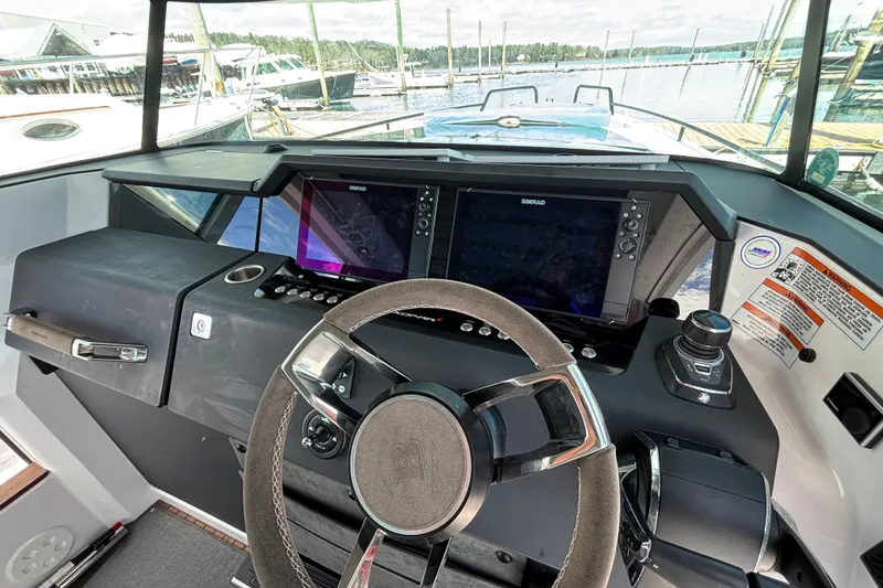 Slide: The Image of 2024 Axopar 37 XC Cross Cabin helm with modern navigation displays and steering wheel. - 27