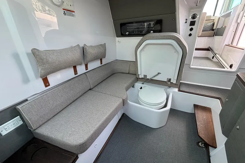 Slide: The Image of 2024 Axopar 37 XC Cross Cabin interior with seating and compact toilet. - 31
