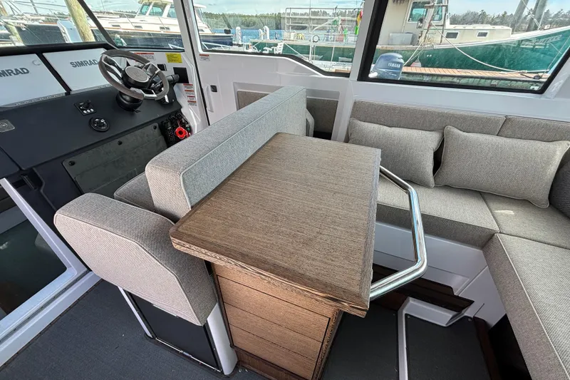 Slide: The Image of 2024 Axopar 37 XC Cross Cabin interior with helm, seating, and table. - 33
