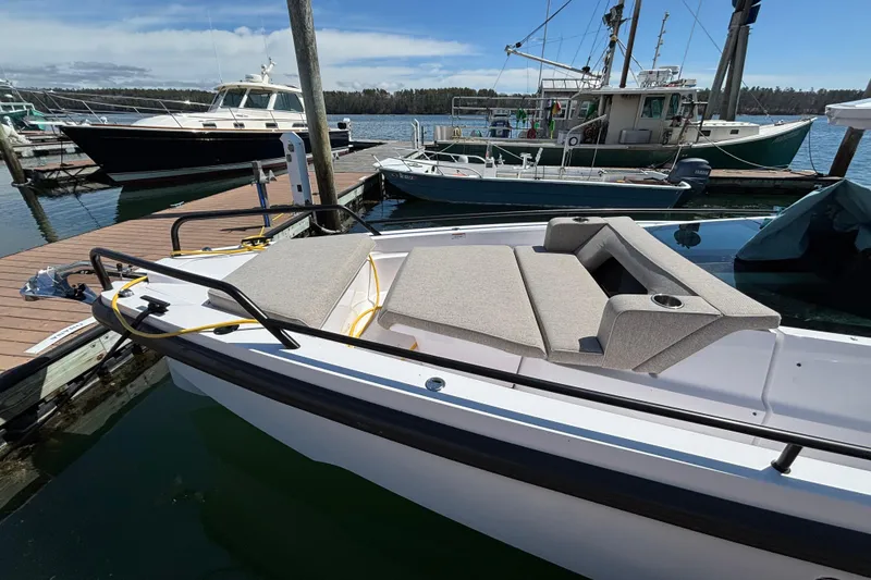 Slide: The Image of 2024 Axopar 37 XC Cross Cabin docked, featuring a spacious sunbed and sleek design. - 4
