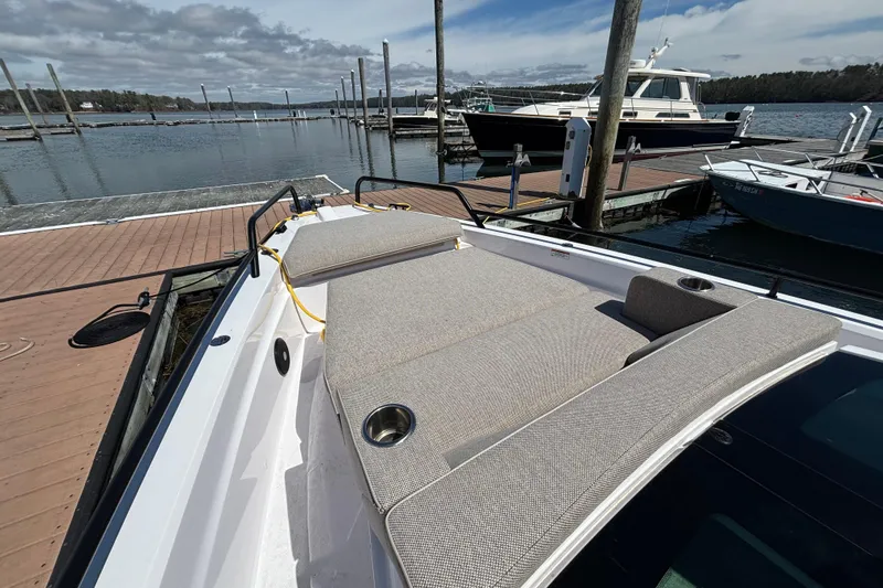 Slide: The Image of 2024 Axopar 37 XC Cross Cabin boat docked with cushioned seating area. - 6