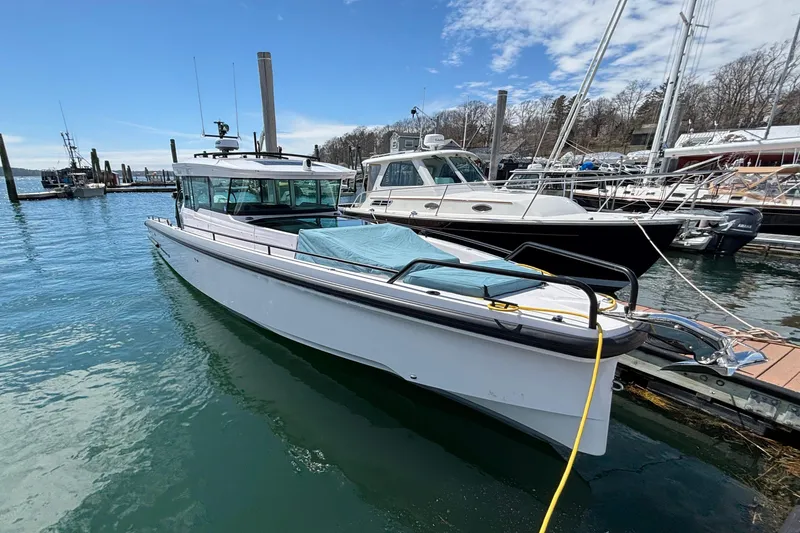 Slide: The Image of 2024 Axopar 37 XC Cross Cabin docked in a marina, clear sky background. - 7