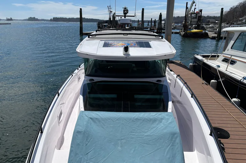 Slide: The Image of 2024 Axopar 37 XC Cross Cabin docked at marina, showcasing sleek design and spacious deck. - 8