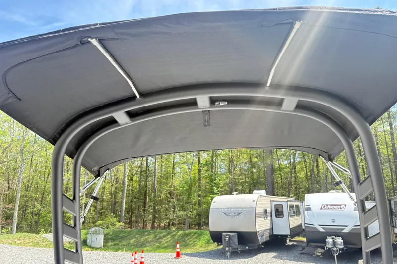 Slide: The Image of 2024 Yamaha Boats 195S canopy with trailers in background, sunny day. - 11