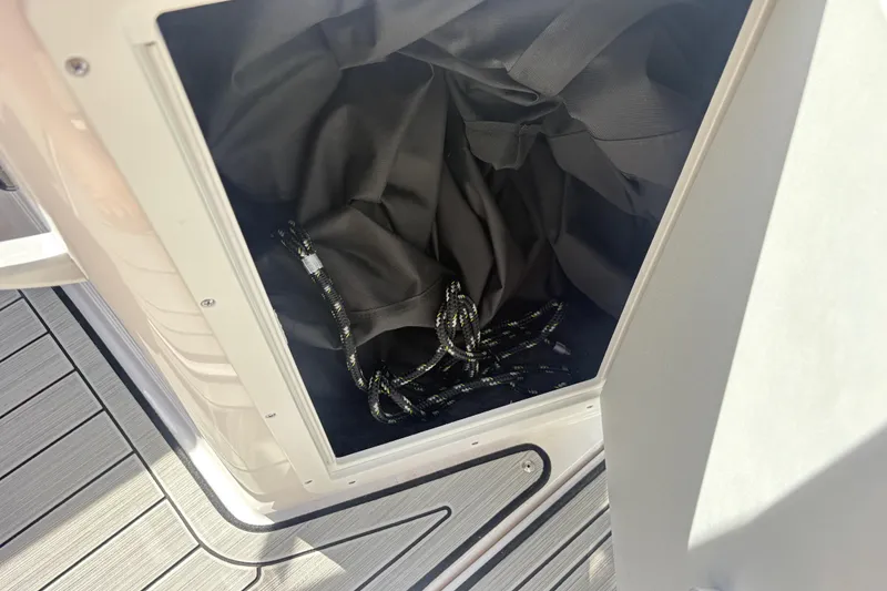 Slide: The Image of Storage compartment on 2024 Yamaha Boats 195S, featuring ropes and fabric. - 13