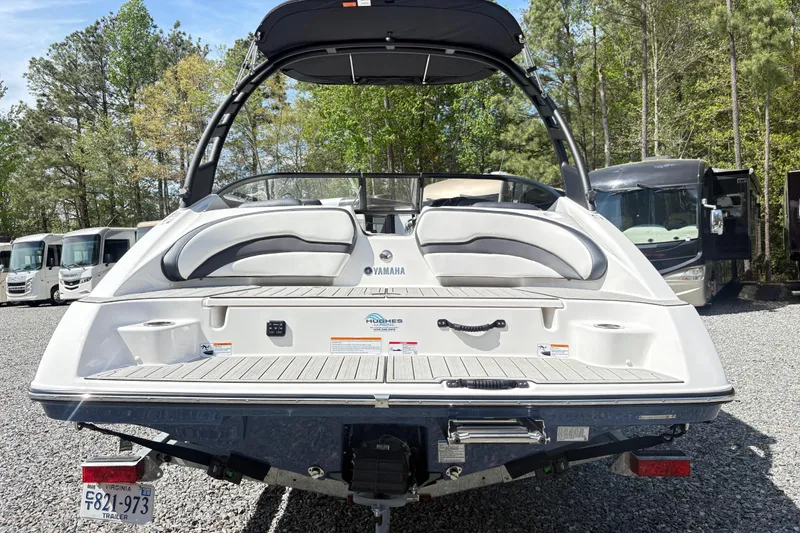 Slide: The Image of 2024 Yamaha Boats 195S rear view, parked outdoors with RVs in the background. - 5