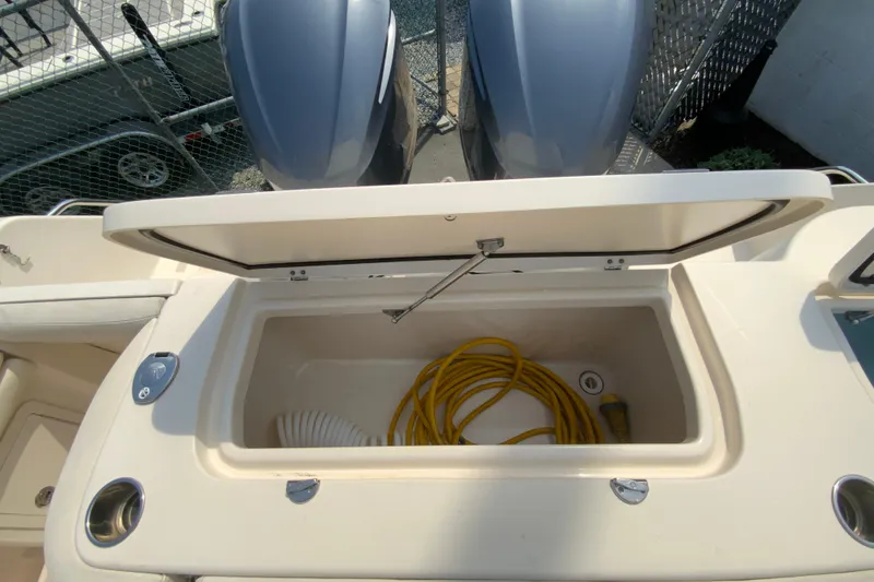 Slide: The Image of Open storage compartment on 2017 Grady-White Freedom 307 boat with yellow hose inside. - 16